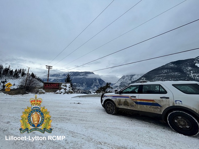 Pictured is a RCMP vehicle by one of 3 Lillooet "Guaranteed Rugged" signs. 